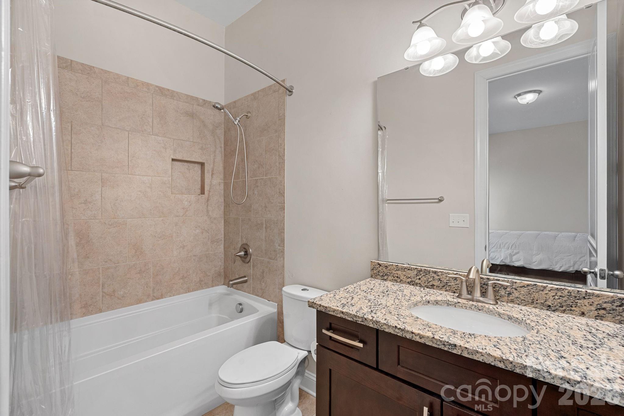 897 Tyne Drive Fort Mill, SC 29715 - Photo 13 of 46 a bathroom with a granite countertop sink a toilet and bathtub