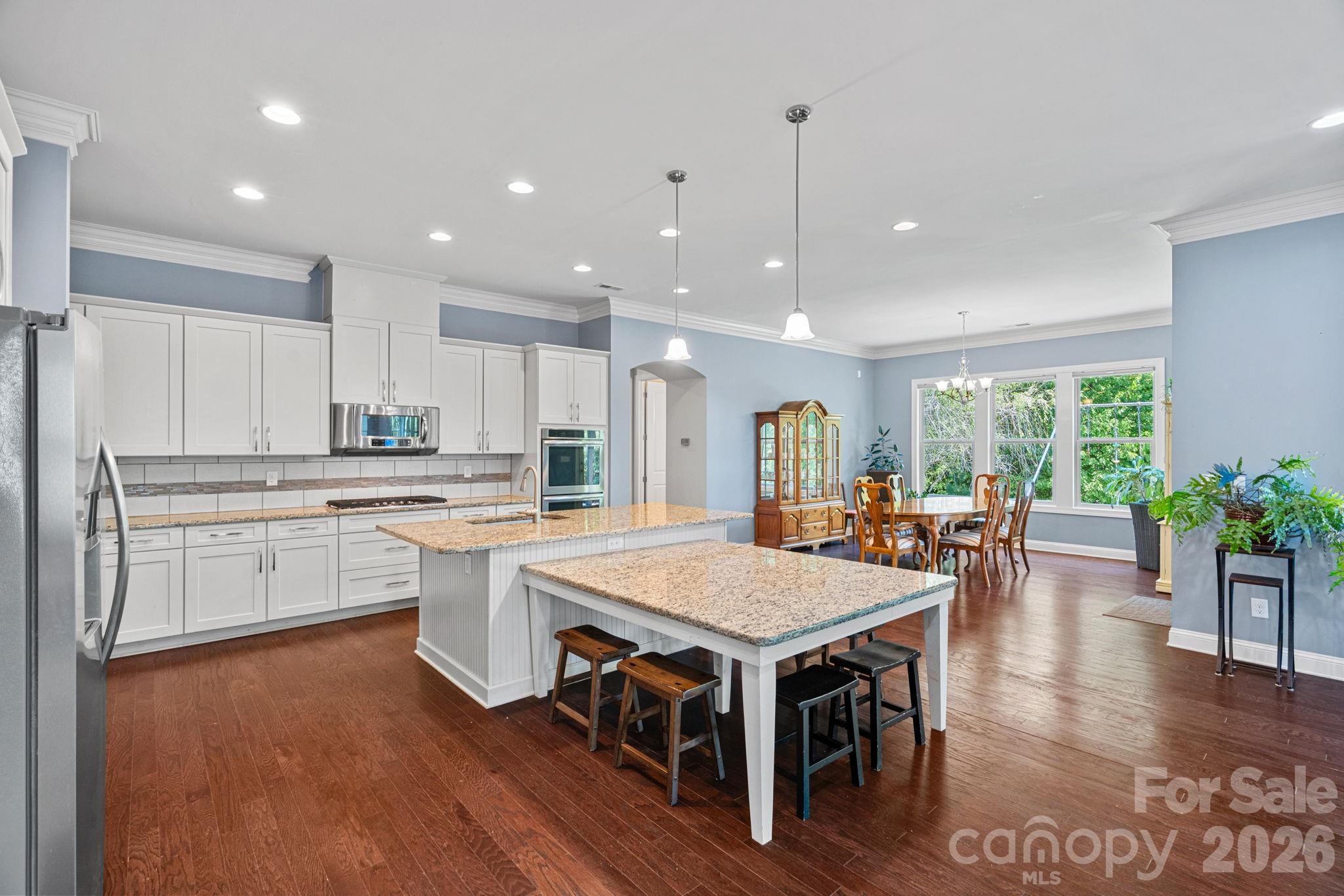 897 Tyne Drive Fort Mill, SC 29715 - Photo 5 of 46 a kitchen with a dining table chairs stove refrigerator and living room view