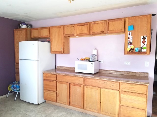 723 Town Road West Chicago, IL 60185 - Photo 8 of 17 a kitchen with a refrigerator and cabinets