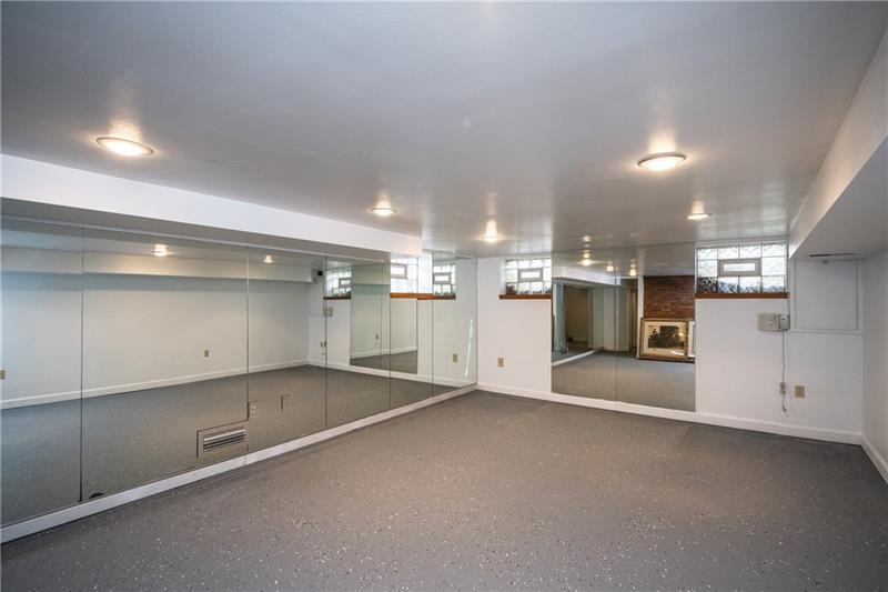 8012 Thompson Run Road Pittsburgh, PA 15237 - Photo 22 of 25 The nicely sized game room on the lower level is mirrored with plenty of natural light coming in through the glass block windows and there is a brick fireplace too!
