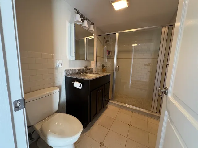 a bathroom with a sink a toilet a mirror and shower