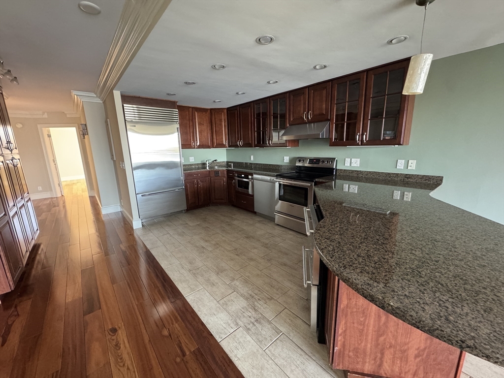 330 Beacon Street, Unit 85 Boston, MA 02116 - Photo 5 of 16 a kitchen with stainless steel appliances granite countertop a sink stove and refrigerator