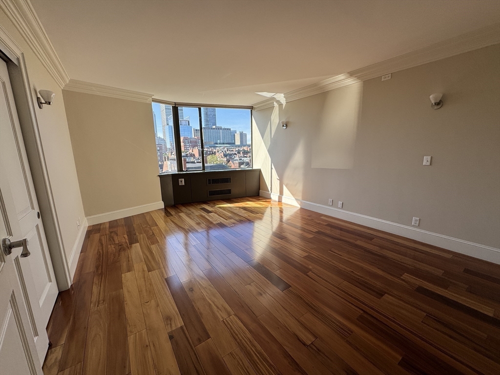 330 Beacon Street, Unit 85 Boston, MA 02116 - Photo 7 of 16 a view of an empty room with wooden floor and a window