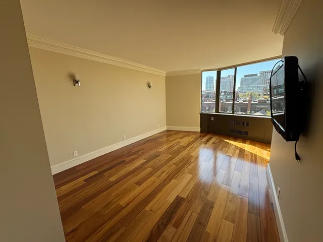 a view of a room with wooden floor and a window