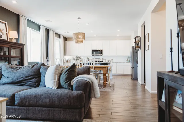 a living room with furniture a refrigerator and a dining table