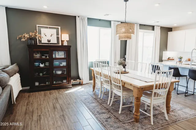 a kitchen with stainless steel appliances granite countertop a sink a stove a refrigerator and white cabinets with wooden floor