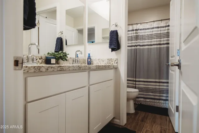 a bathroom with a granite countertop sink a shower and a mirror