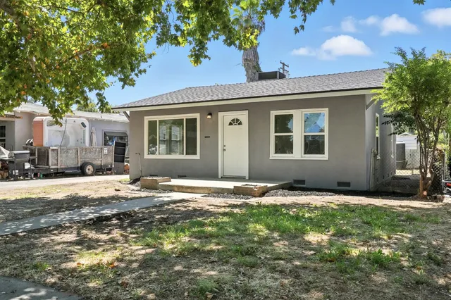 a backyard of a house with table and chairs