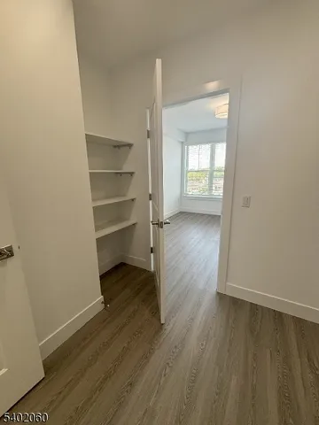 a view of a room with wooden floor closet and windows