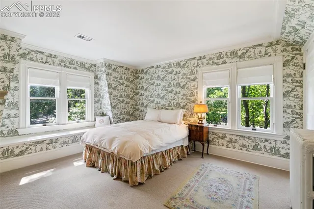 a bed sitting in a bedroom next to a window