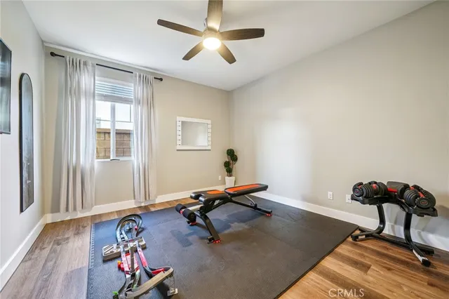 a room with gym equipment and wooden floor