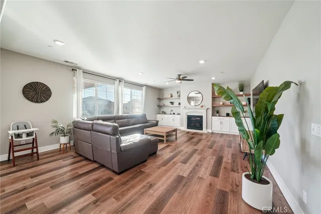 a living room with furniture potted plant and a wooden floor