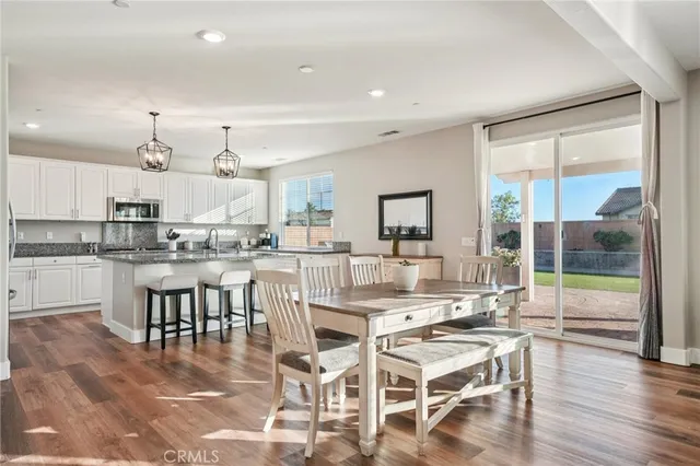 a dining room with stainless steel appliances kitchen island granite countertop a dining table chairs and view living room