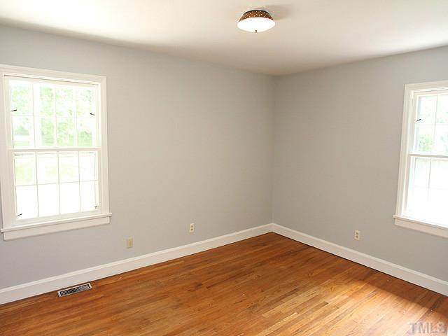 2452 Oxford Road Raleigh, NC 27608 - Photo 15 of 25 an empty room with wooden floor and windows