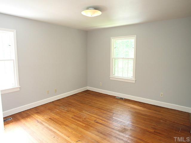 2452 Oxford Road Raleigh, NC 27608 - Photo 16 of 25 an empty room with wooden floor and windows