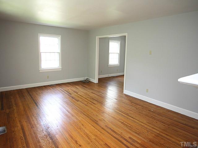 2452 Oxford Road Raleigh, NC 27608 - Photo 4 of 25 a view of an empty room with wooden floor and a window