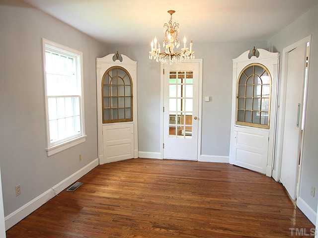 2452 Oxford Road Raleigh, NC 27608 - Photo 5 of 25 an empty room with wooden floor chandelier and windows