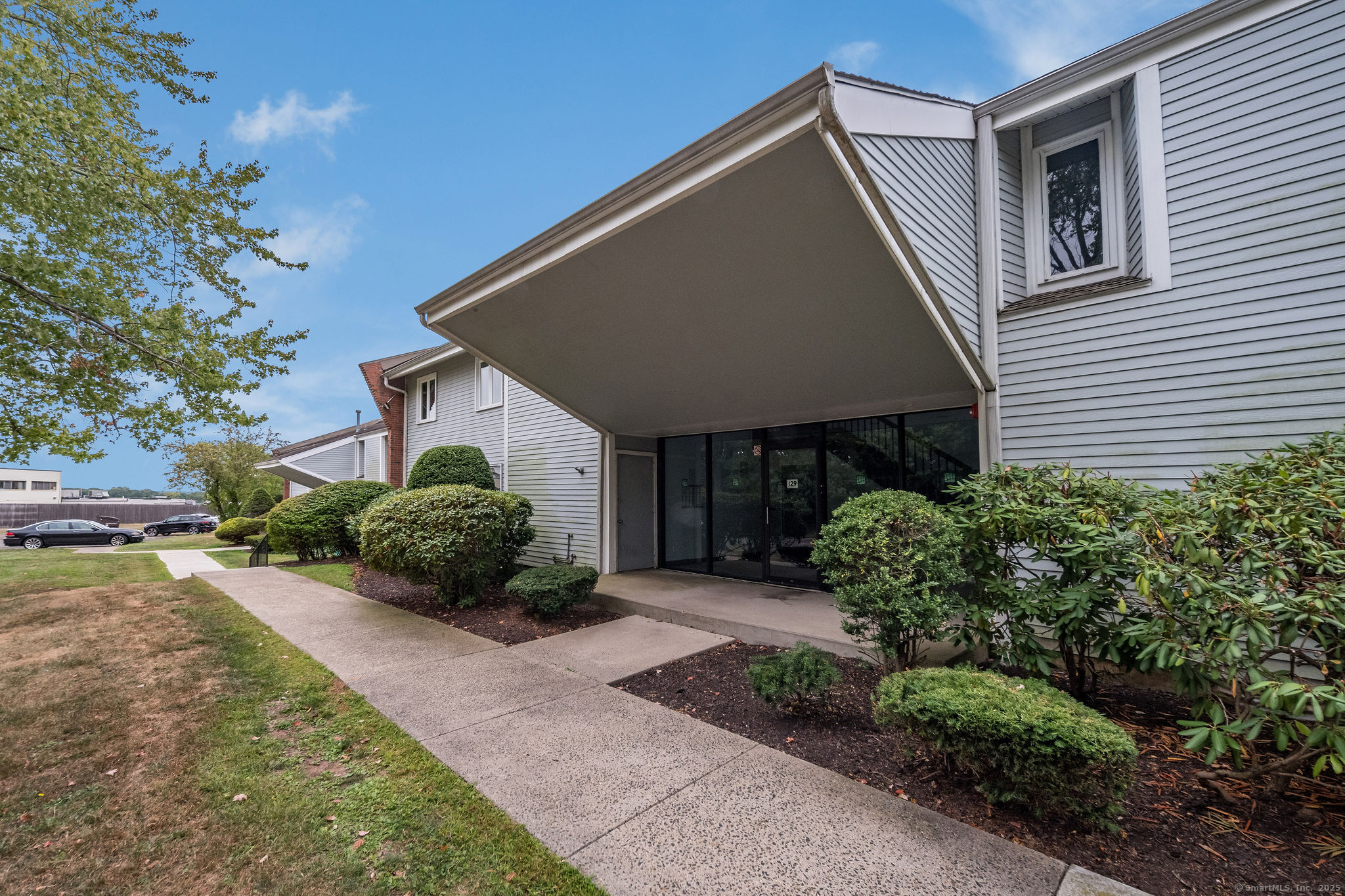 129 Florence Road, Unit 1B Branford, CT 06405 - Photo 1 of 1 a front view of a house with a yard and outdoor seating