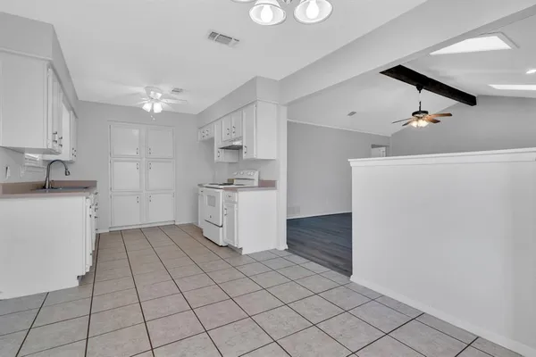 a kitchen with a sink a refrigerator and cabinets
