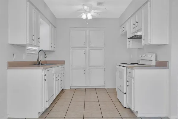 a kitchen with granite countertop white cabinets and white appliances
