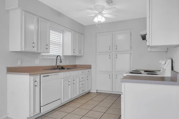 a kitchen with white cabinets and white appliances