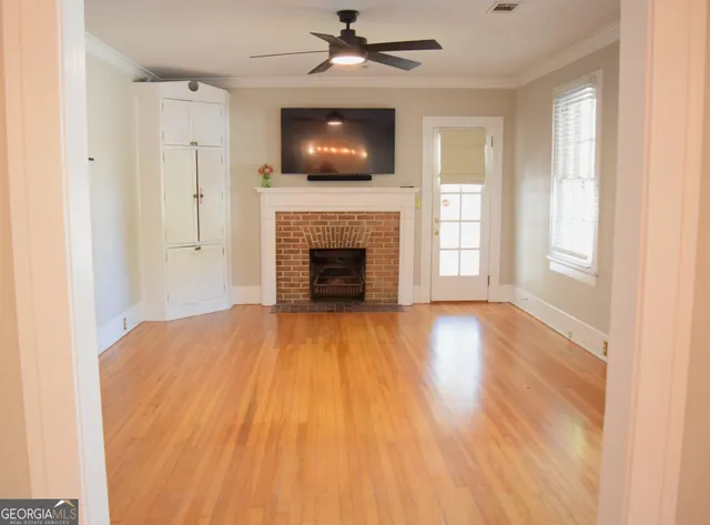 a view of empty room with fireplace and wooden floor