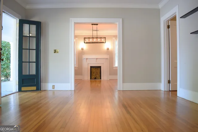 a view of a hallway with wooden floor and a fireplace