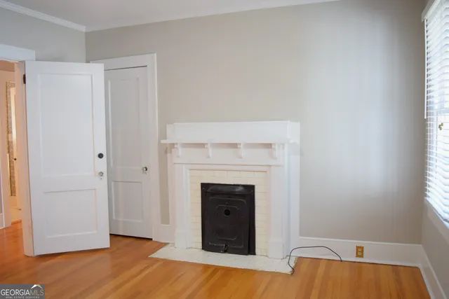 a view of a livingroom with wooden floor and a fireplace