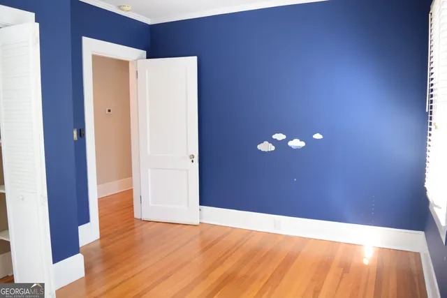a view of empty room with wooden floor
