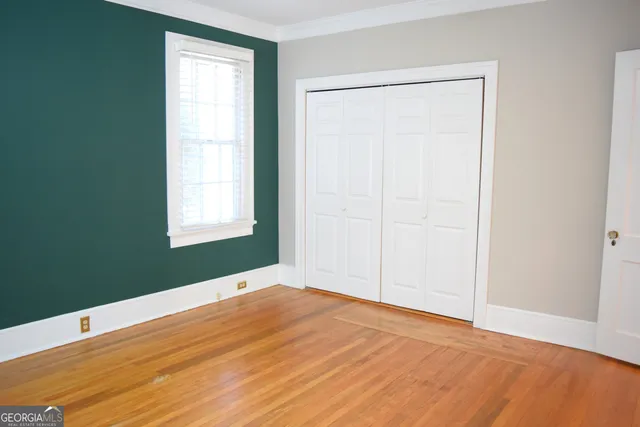 an empty room with window and closet area