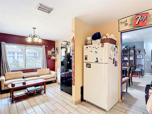 a view of a dining room with furniture a chandelier and wooden floor