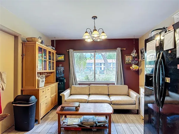 a living room with furniture a chandelier and a large window