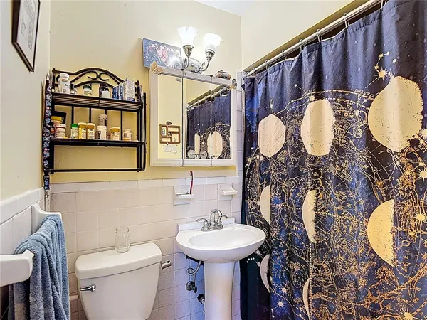 a bathroom with a toilet sink and mirror