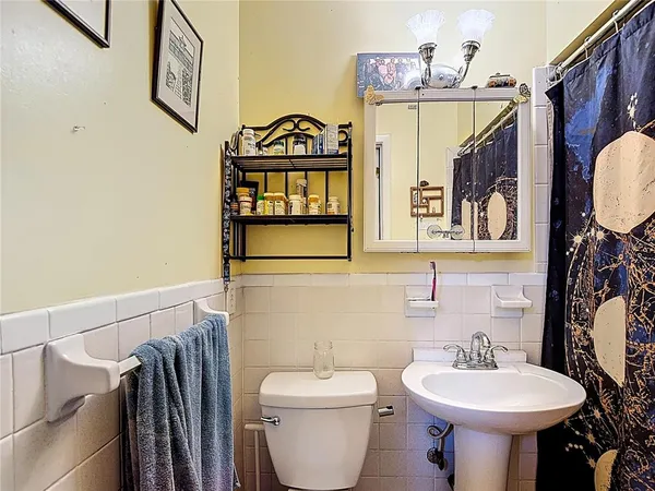 a bathroom with a sink toilet and mirror