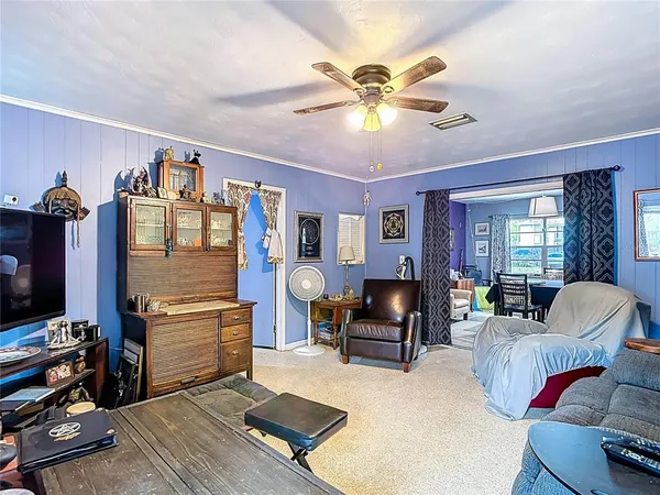 a living room with furniture and a ceiling fan