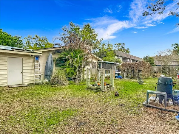 a view of a chair and table in backyard of the house