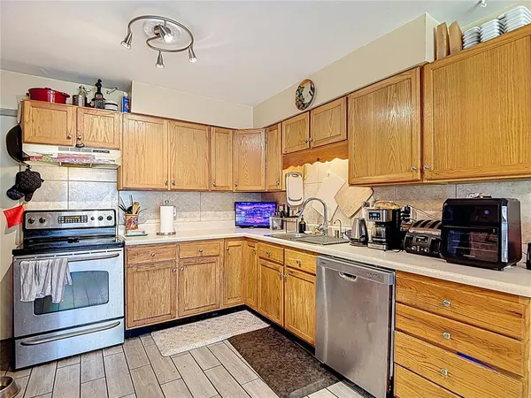 a kitchen with stainless steel appliances granite countertop a sink stove and cabinets
