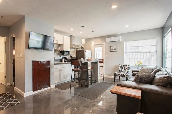 a living room with furniture a flat screen tv and a window