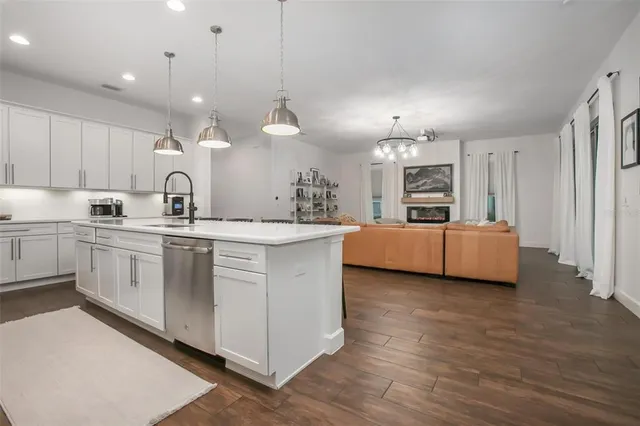 a kitchen with kitchen island granite countertop a sink cabinets and wooden floor
