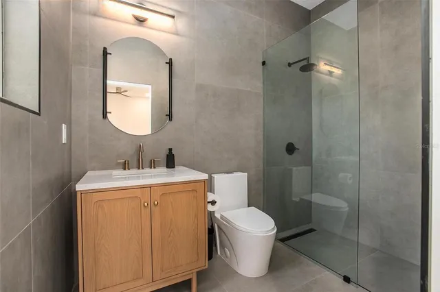 a bathroom with a granite countertop toilet sink and mirror