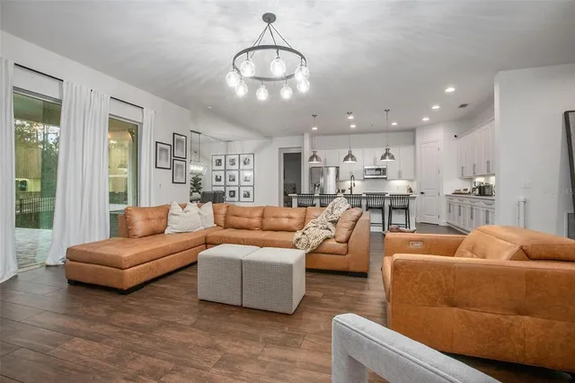 a living room with furniture kitchen and a chandelier