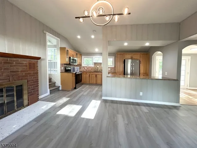 a view of large kitchen with refrigerator and wooden floor