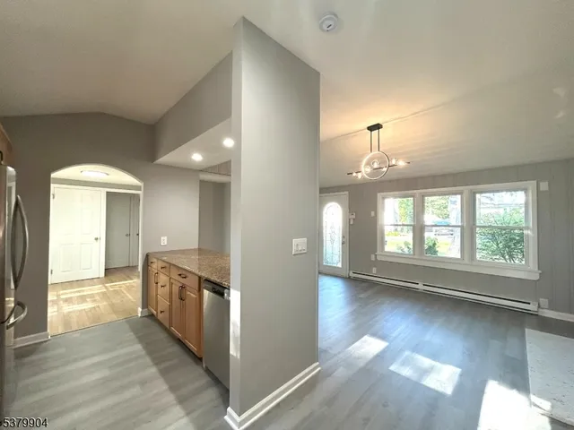 an empty room with wooden floor and outdoor view