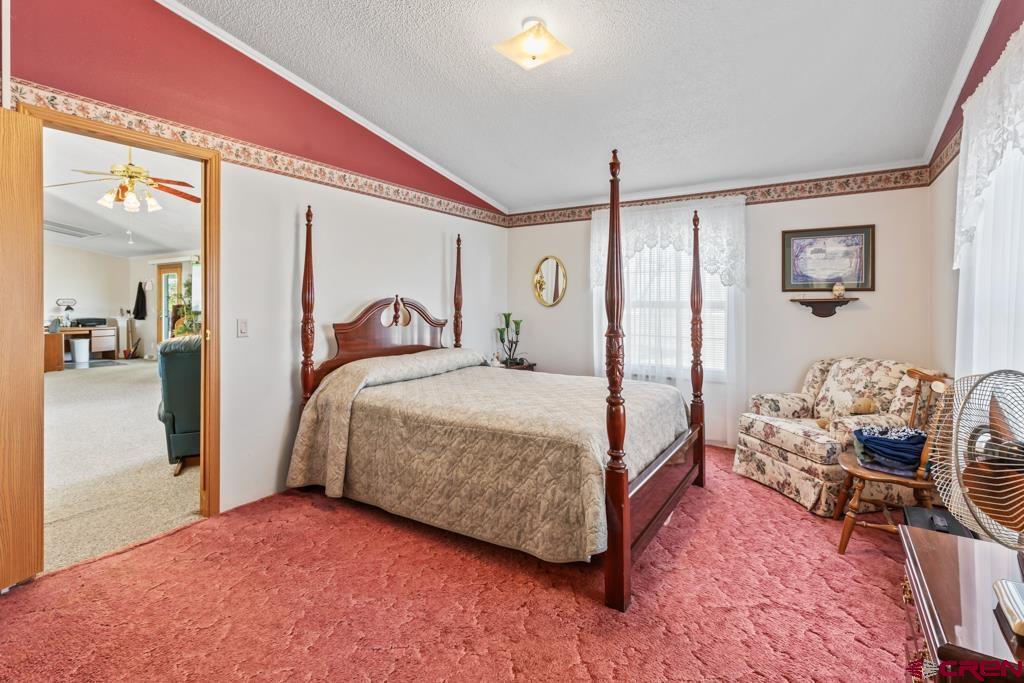 7655 6075th Road Olathe, CO 81425 - Photo 11 of 24 a bedroom with a bed and a mirror