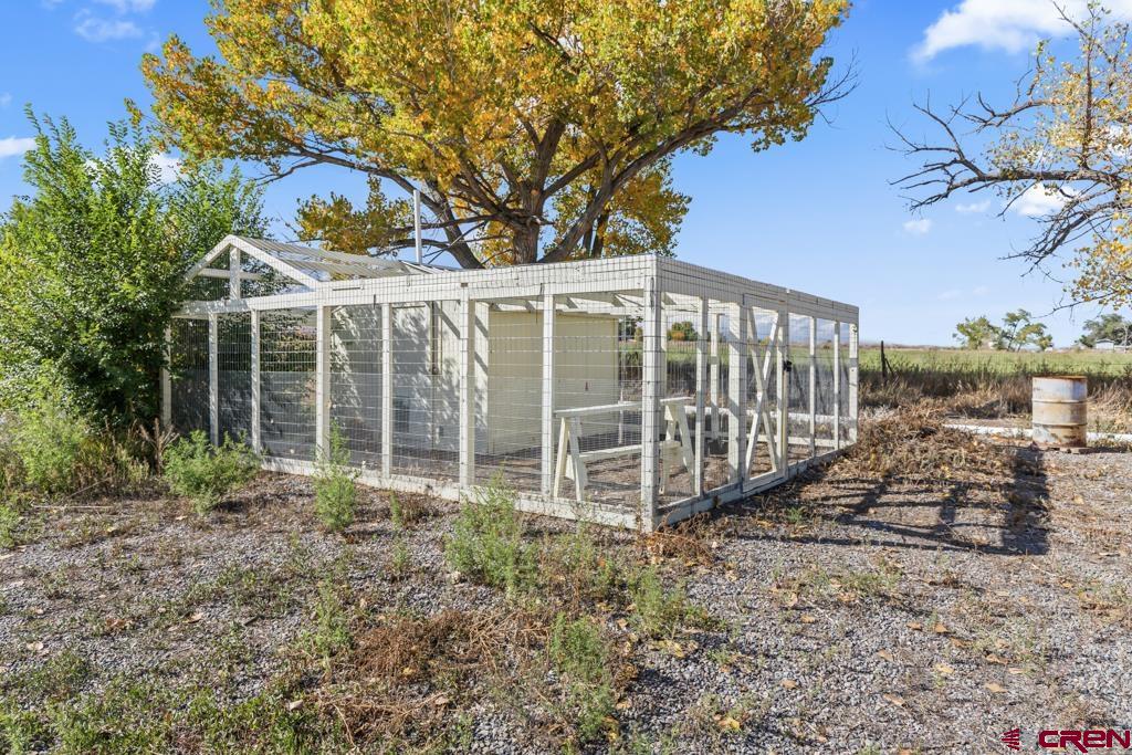 7655 6075th Road Olathe, CO 81425 - Photo 21 of 24 a view of a backyard with large trees and wooden fence