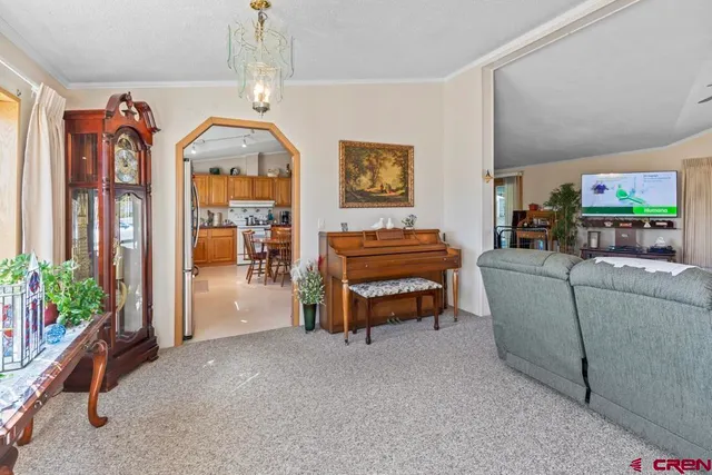 a living room with furniture a piano and a chandelier