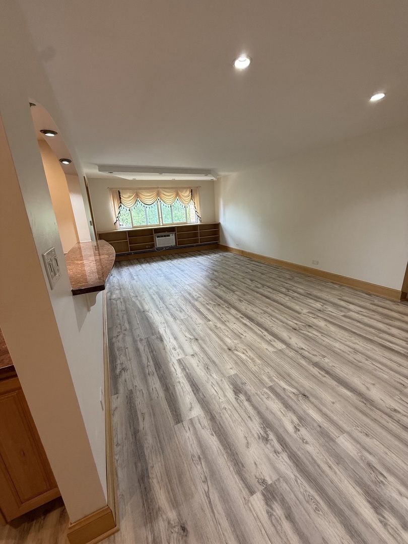 728 Dempster Street, Unit 210 Mount Prospect, IL 60056 - Photo 12 of 27 a view of empty room with wooden floor and fan