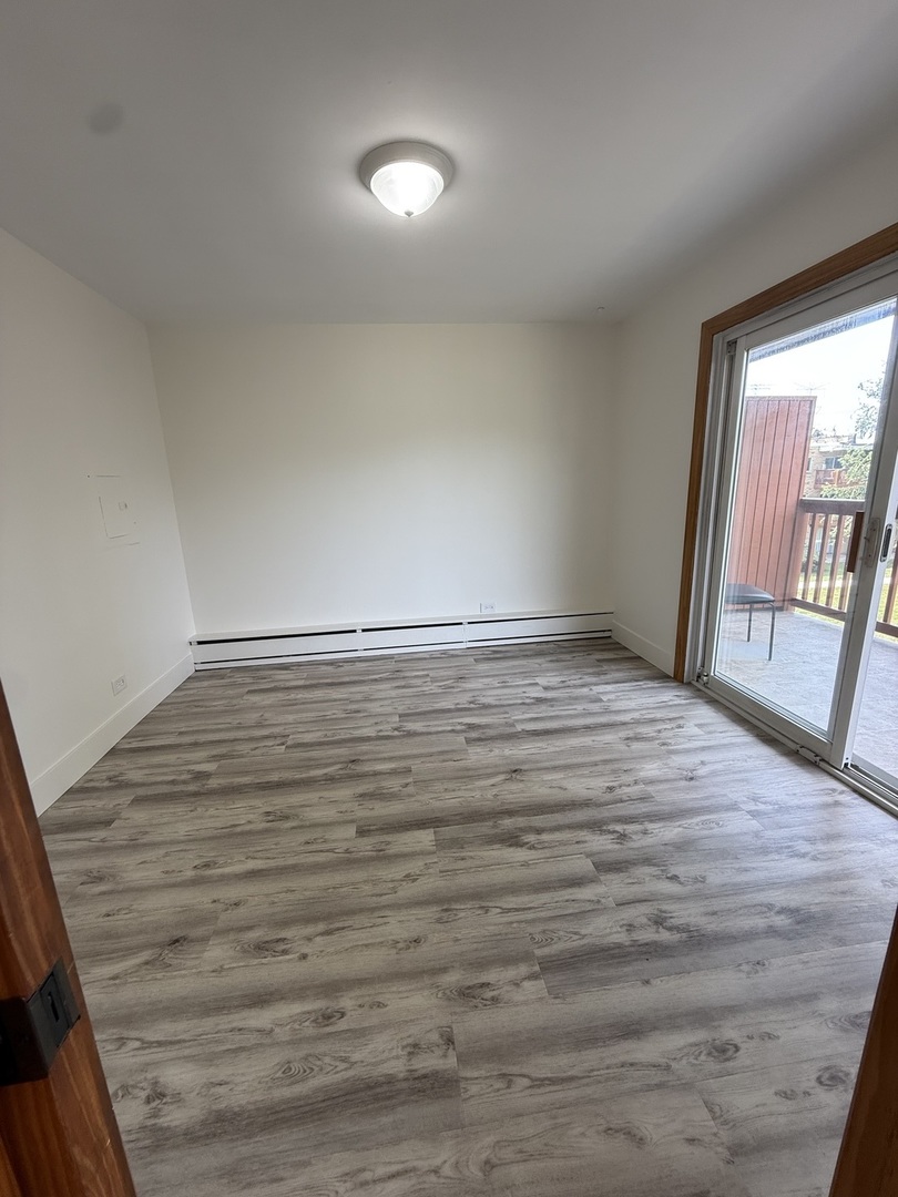 728 Dempster Street, Unit 210 Mount Prospect, IL 60056 - Photo 21 of 27 a view of an empty room with glass door and wooden floor