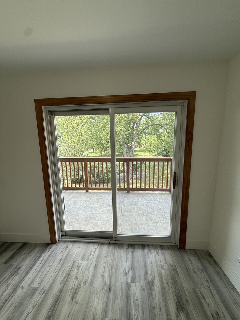 728 Dempster Street, Unit 210 Mount Prospect, IL 60056 - Photo 23 of 27 an empty room with wooden floor and windows