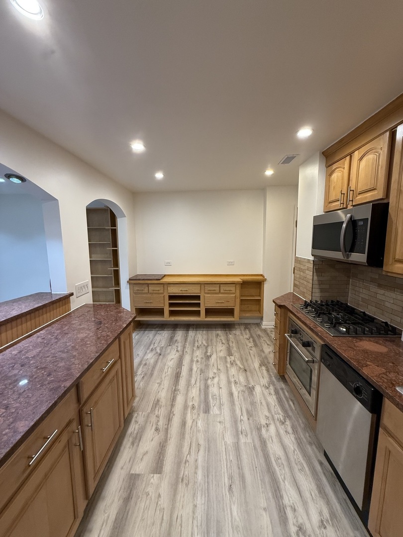 728 Dempster Street, Unit 210 Mount Prospect, IL 60056 - Photo 3 of 27 a kitchen with stainless steel appliances granite countertop a stove a sink and a refrigerator